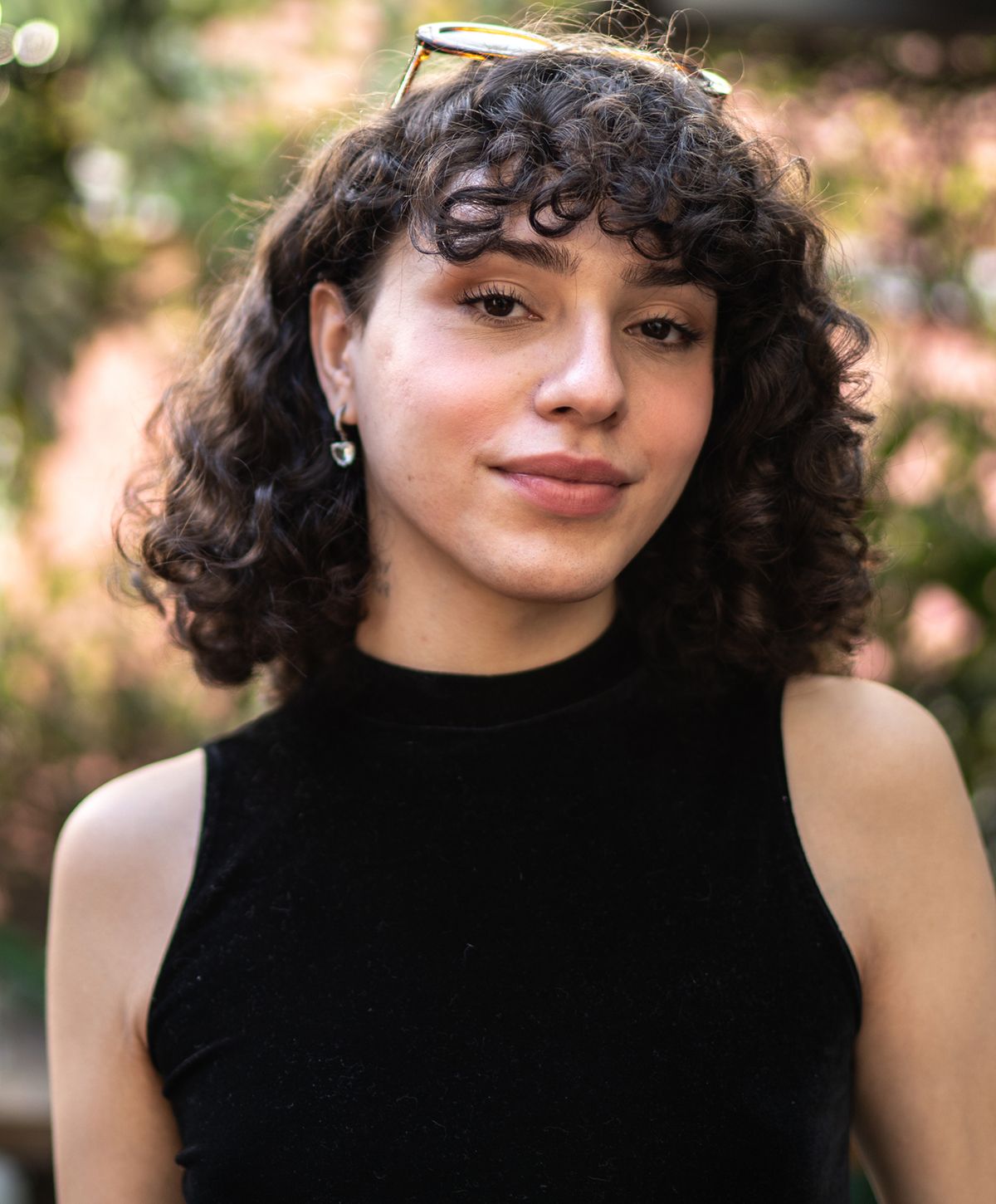 Person with curly hair in black top.