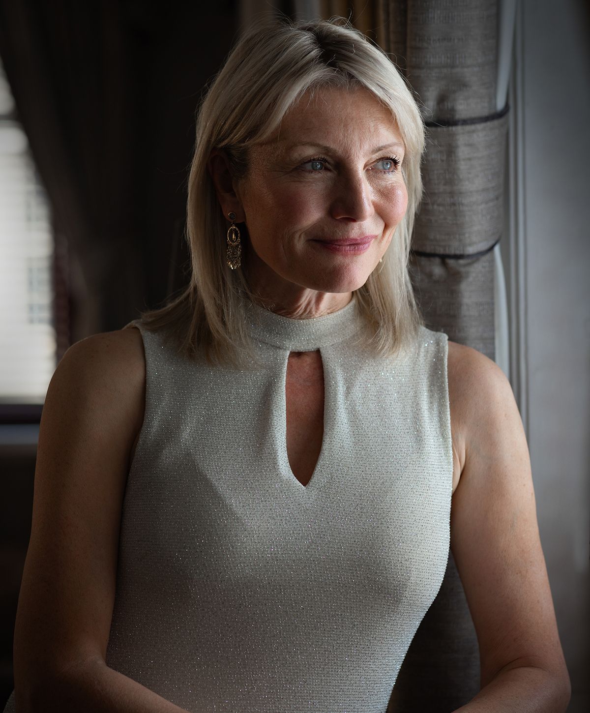 Elegant woman with light blonde hair, smiling.