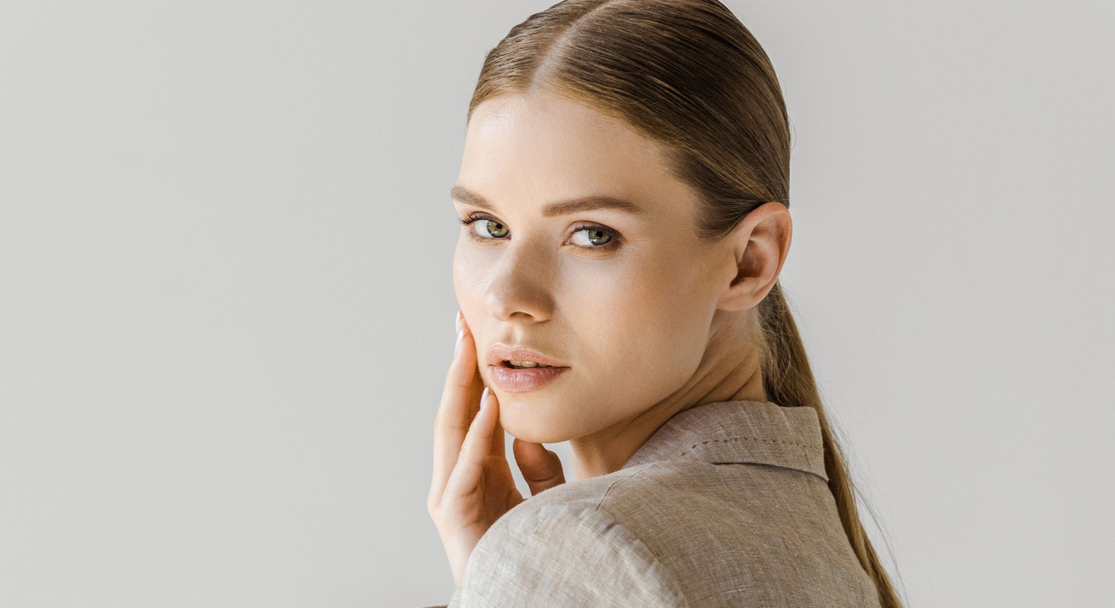 Woman with elegant hairstyle and neutral background.