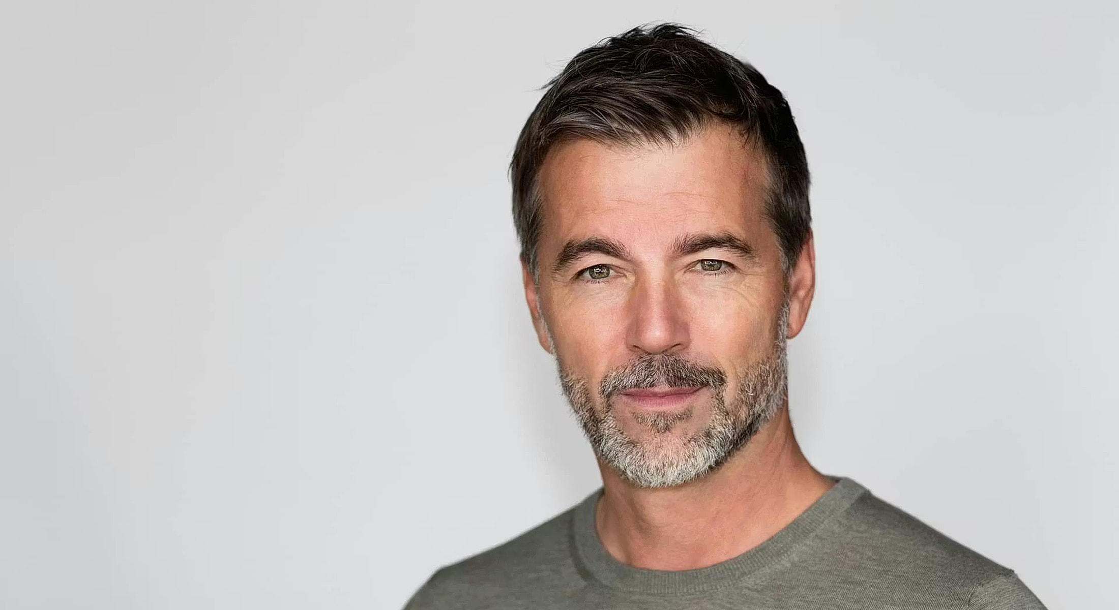 Man with short hair and beard, smiling.