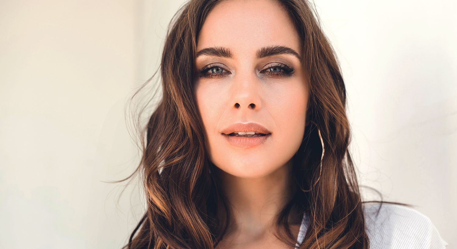 Woman with long brown hair and captivating gaze.